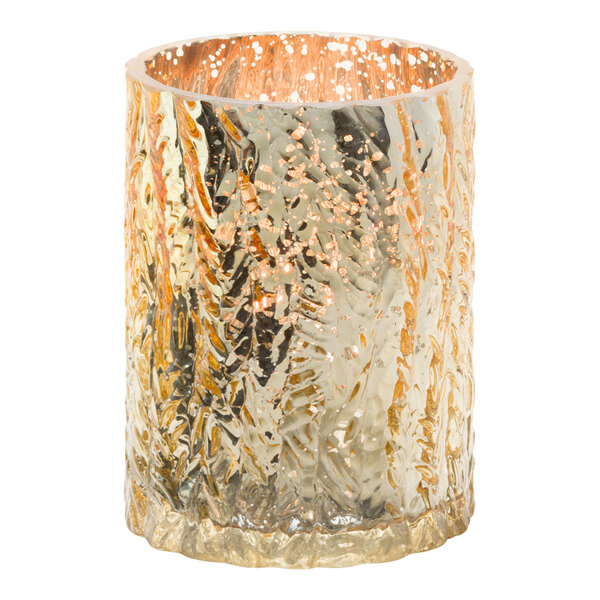 A Hollowick Rustic Mercury Gold glass candle holder with a lit candle inside.