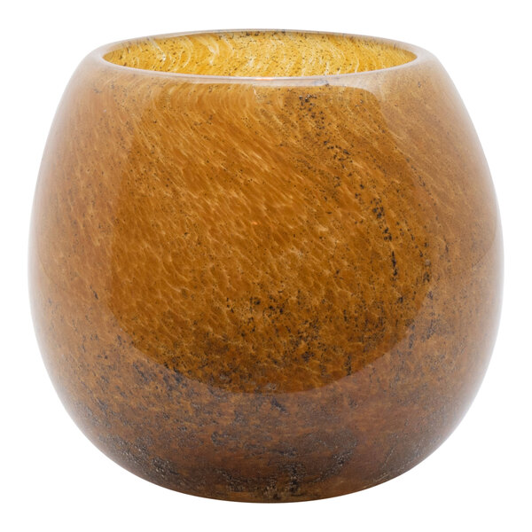 A round brown Hollowick art glass votive with black specks on a brown surface.