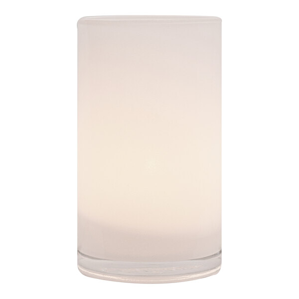 A white Silo glass lamp with a lit candle inside.