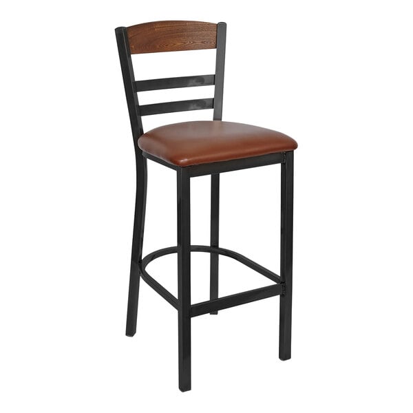 A BFM Seating black steel barstool with a brown wood back and seat with brown vinyl cushion.