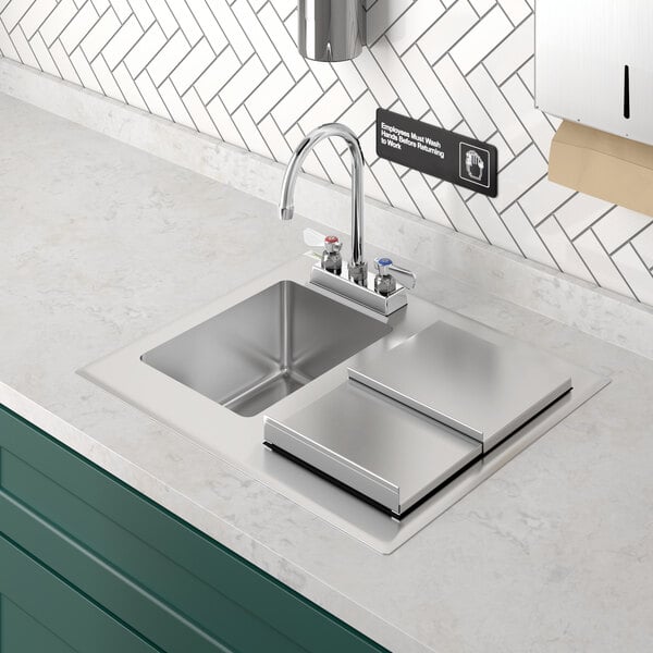 A Regency stainless steel drop-in hand sink with faucet on a counter.
