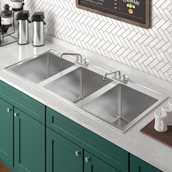 A stainless steel Regency drop-in sink with (2) faucets.