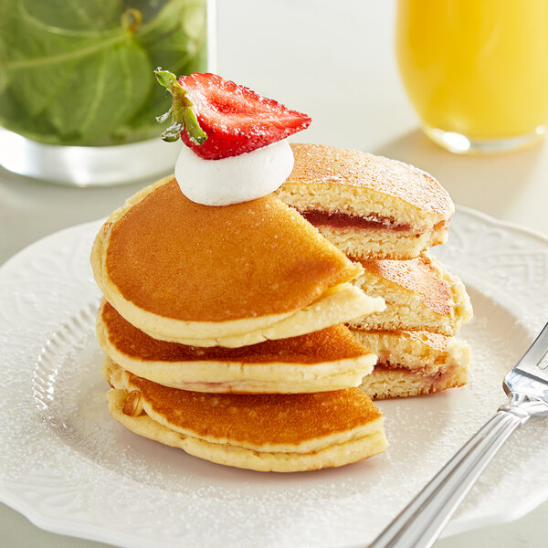 A close up of a White Toque strawberry filled pancake.