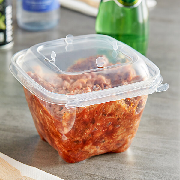 A plastic Inline Plastics Safe-T-Chef deli container of food with a vented dome lid.