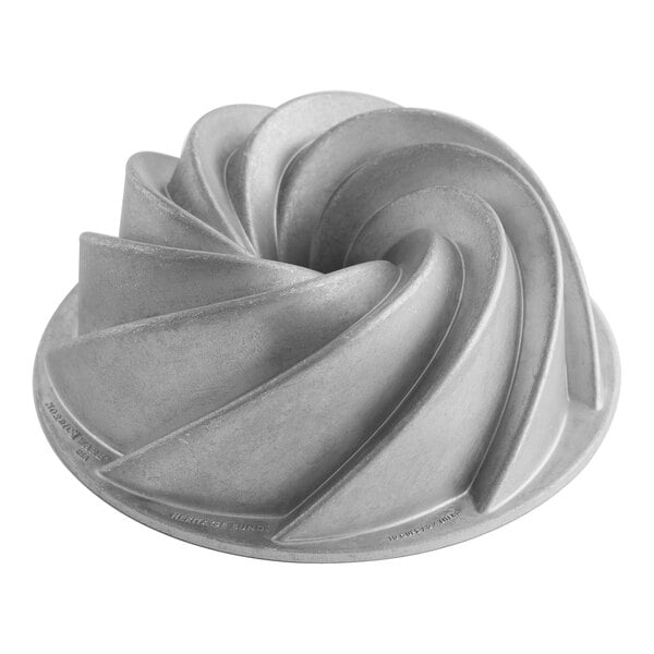A white Nordic Ware cast aluminum bundt cake pan with a spiral design.