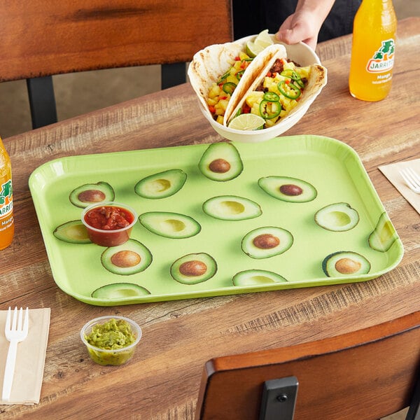 A Cambro rectangular tray with tacos, guacamole, and a drink on it.