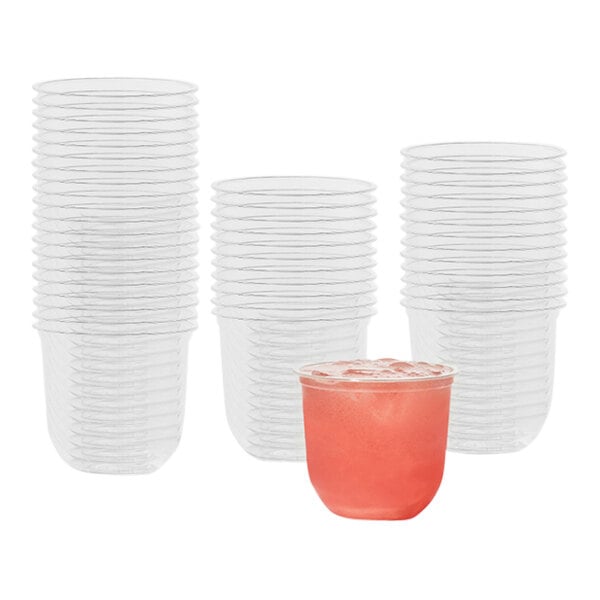 A stack of clear Tossware plastic cups filled with pink drinks.