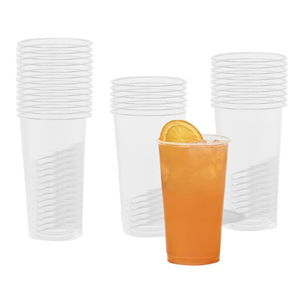 A Tossware Natural plastic cup with a straw and orange drink.