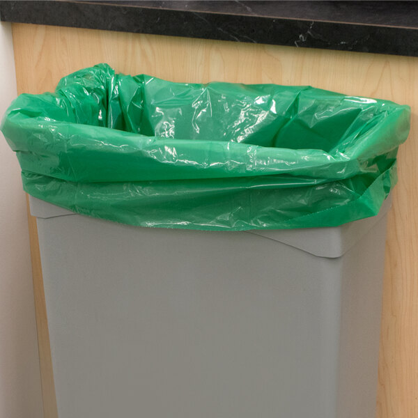 A garbage can with a green Low Density Trash Can Liner over it.