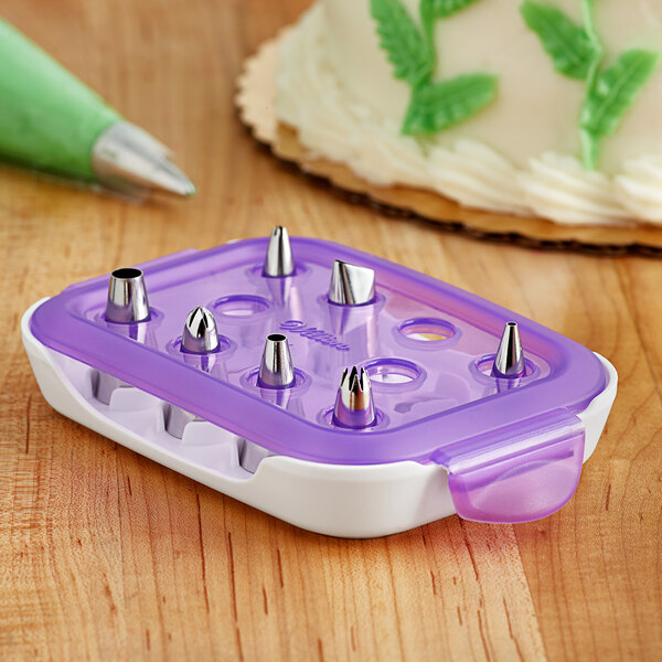 A plastic container with Wilton stainless steel piping tips and a purple label.