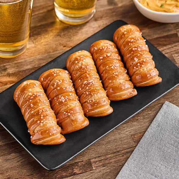 A plate of Eastern Standard Provisions Turnbuckle Soft Pretzel Sticks on a table.