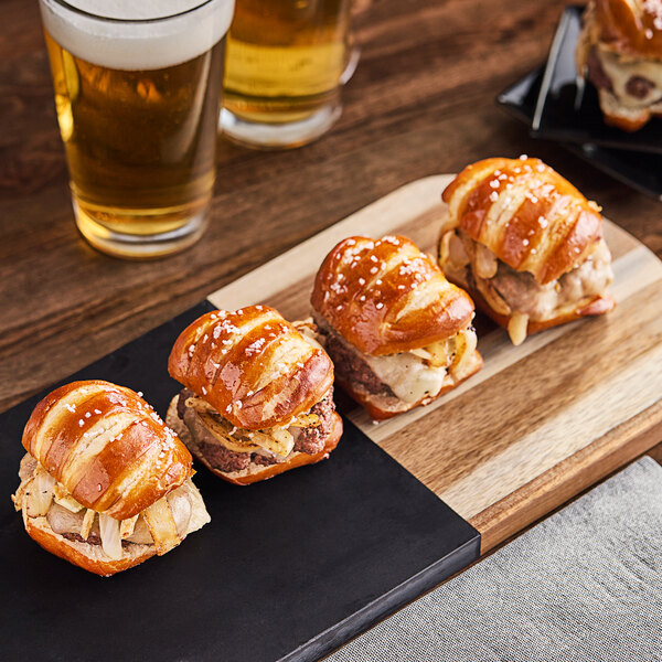 A tray of Eastern Standard Provisions Soft Pretzel Slider Buns with sandwiches on it.