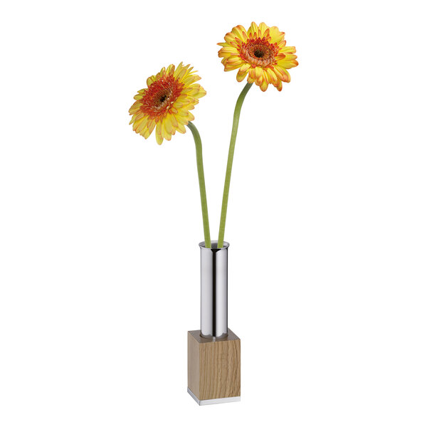 A metal and natural wood vase with two yellow flowers.