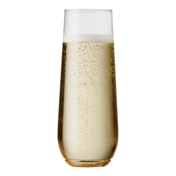 A close up of a Tossware plastic champagne flute filled with champagne and bubbles.