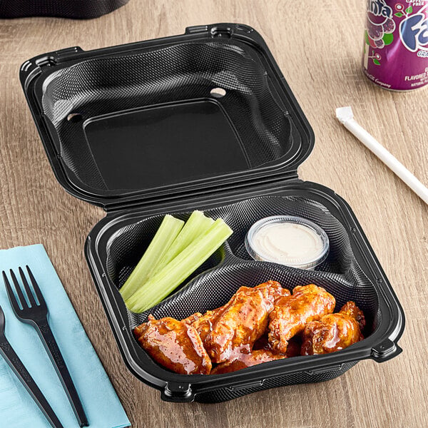 A close up of a black Genpak 3-compartment container with chicken wings and celery.