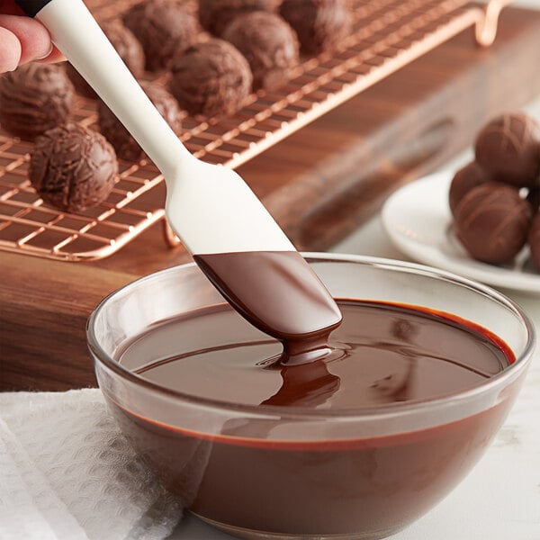 A person pouring TCHO dark chocolate into a bowl.