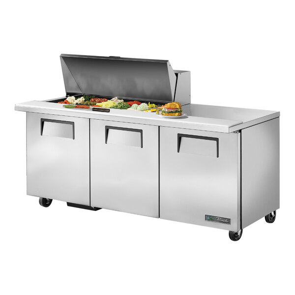 A True 3 door stainless steel sandwich prep table with food on a counter.