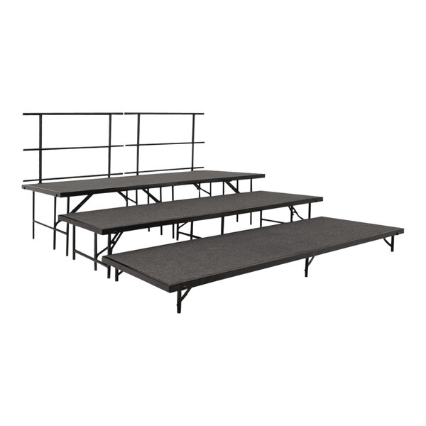 A set of three black National Public Seating stage risers with guardrails and gray carpet.