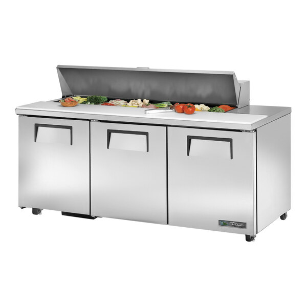 A True TSSU-72-16-HC refrigerated prep table with food on it.