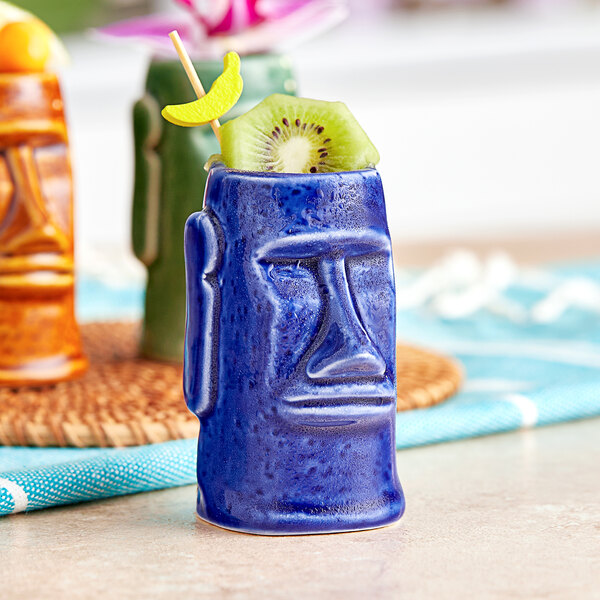 A blue ceramic Acopa Tiki Mug with a kiwi in it.