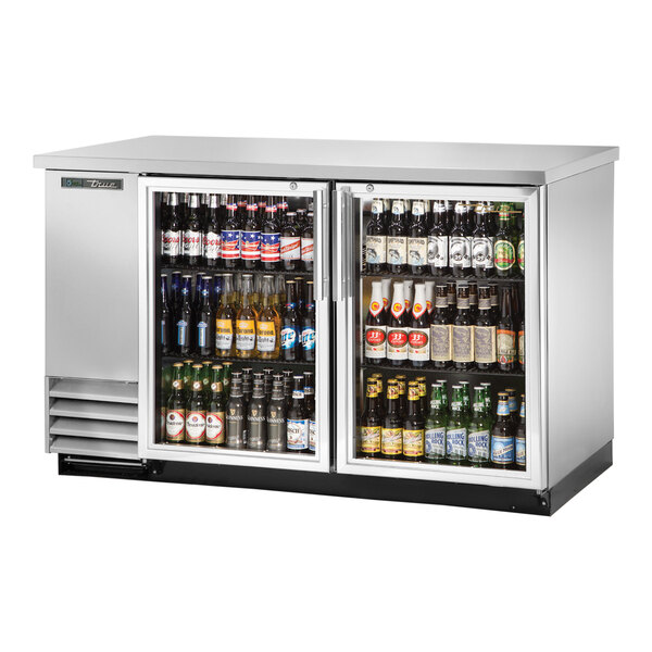 A True stainless steel back bar refrigerator with glass doors filled with bottles of beer.
