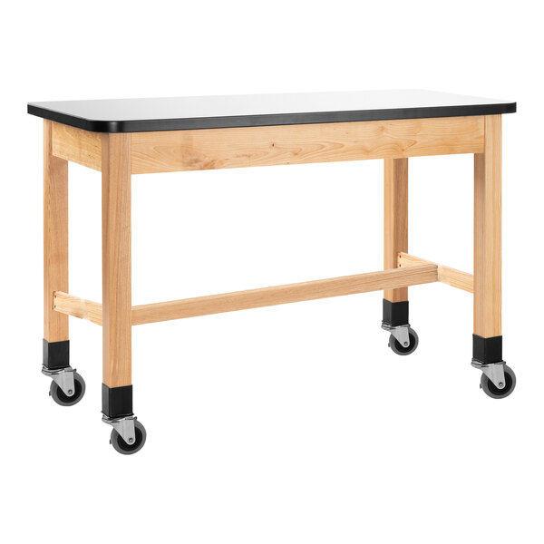 A wooden National Public Seating science lab table with a whiteboard top and casters.