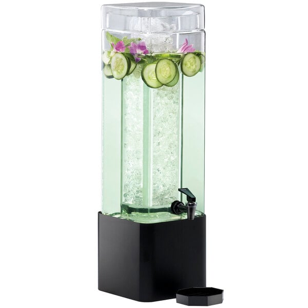 A Cal-Mil square glass beverage dispenser with a black metal base filled with cucumber and ice water.