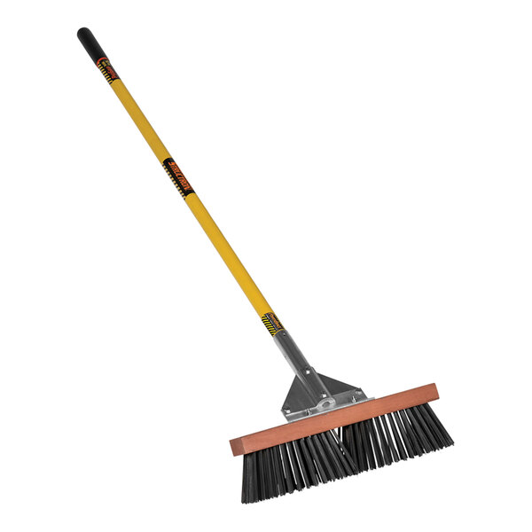 A Structron steel wire push broom with a yellow fiberglass handle.