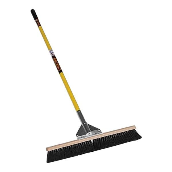 A Structron general purpose push broom with a yellow and black handle.