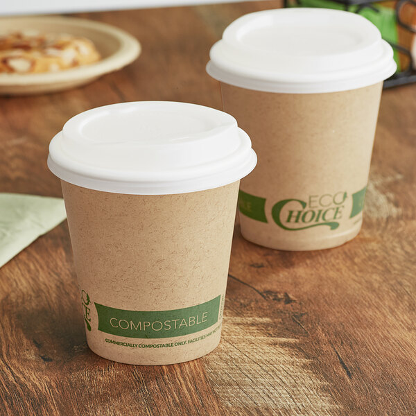 Two EcoChoice paper hot cups with PLA lids on a table.