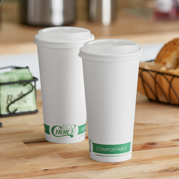 Two white EcoChoice paper hot cups on a table.