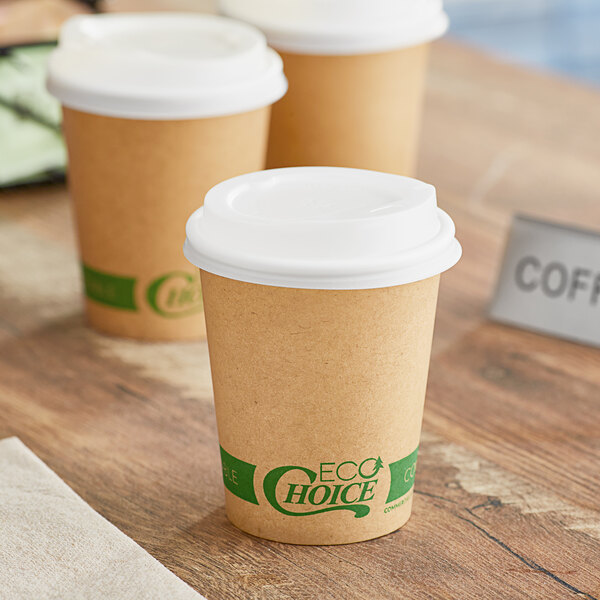 A group of EcoChoice Kraft paper coffee cups with white PLA lids on a table.