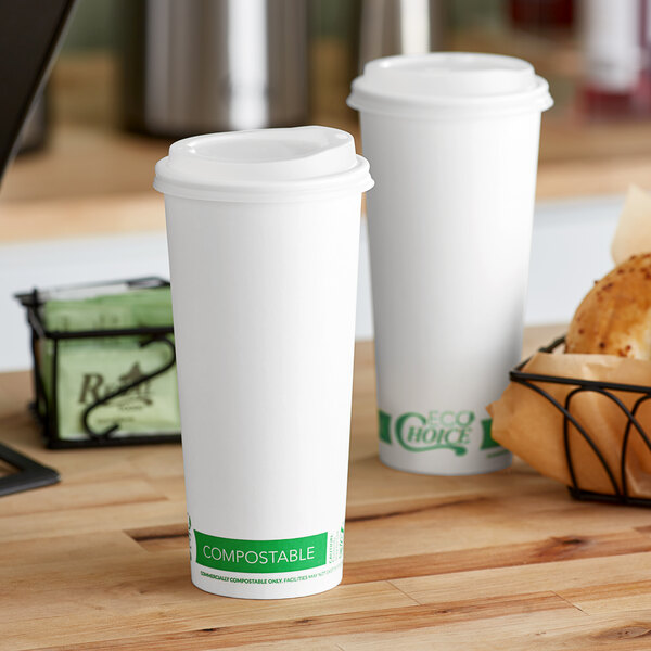 Two EcoChoice white paper cups with PLA lids on a table.