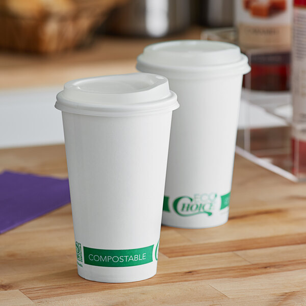 Two EcoChoice white paper cups with PLA lids on a wooden surface.