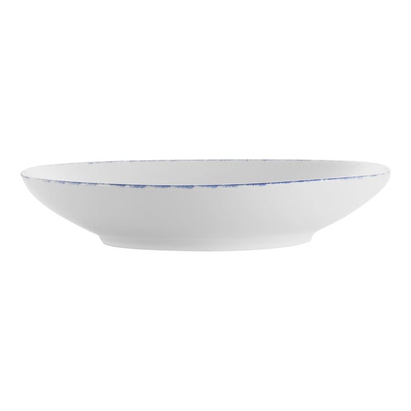 A white porcelain pasta bowl with blue sponged accents on the rim.