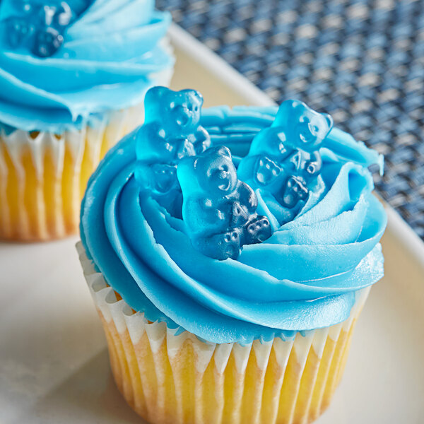 A cupcake with blue frosting and Albanese blue raspberry gummy bears on top.