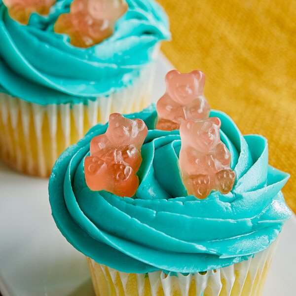 A cupcake with blue frosting and Albanese Pink Gummi Bears on top.