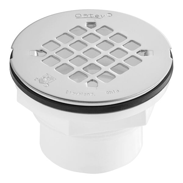 A white Oatey PVC shower drain with a black snap-in strainer.
