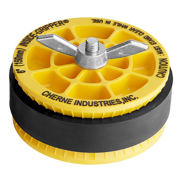 A yellow and black Cherne Inside of Pipe Gripper Plug disc with a screw on top.