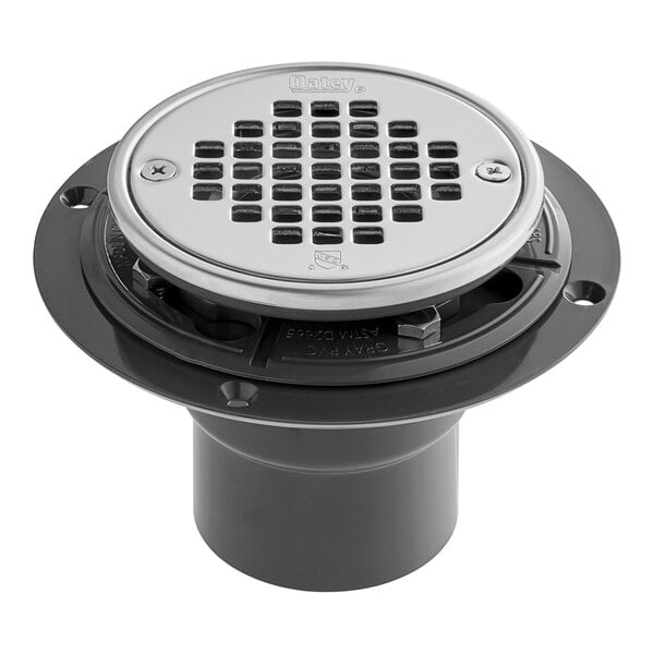 A round stainless steel Oatey shower drain strainer with holes.