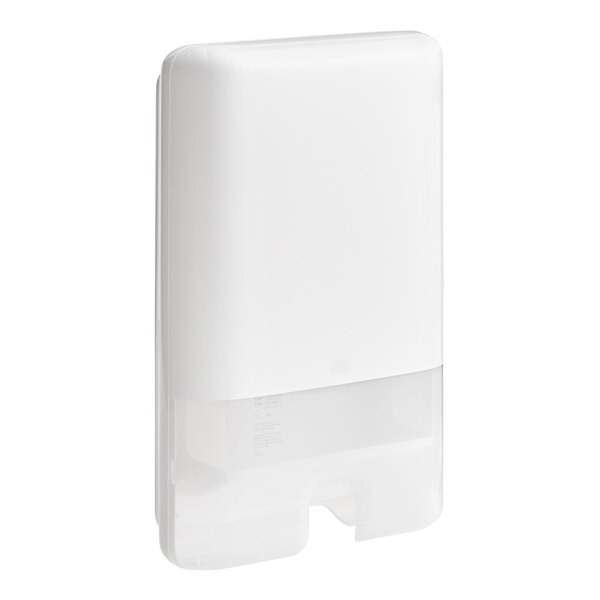 A white rectangular Tork wall mount multifold hand towel dispenser with a white cover.