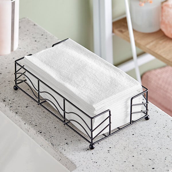 A black metal tray with a stack of white Hoffmaster Linen-Like guest towels.