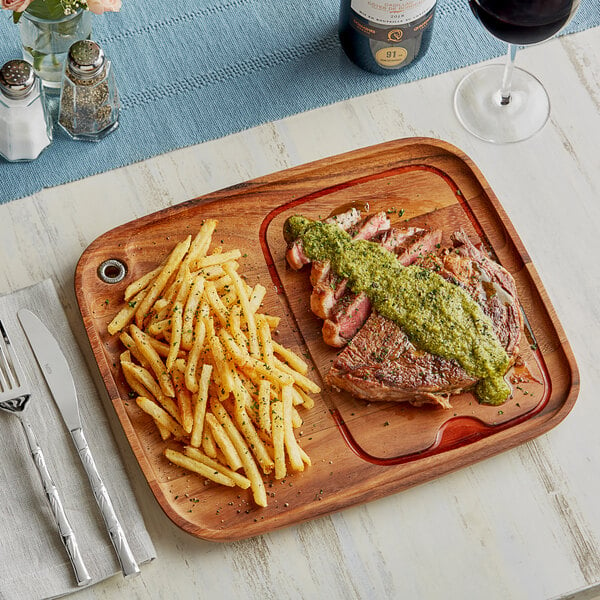 An Ironwood Gourmet acacia serving board with a steak and fries on it.