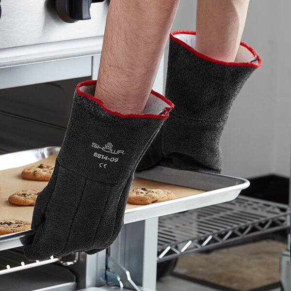 A person wearing Showa neoprene heat-resistant gloves holds a tray of cookies.