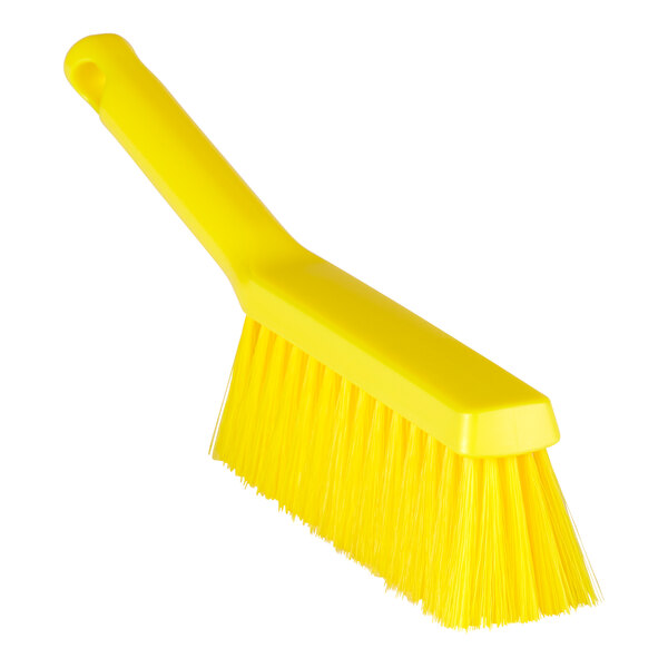 A close up of a yellow Remco ColorCore bench brush with long bristles and a handle.