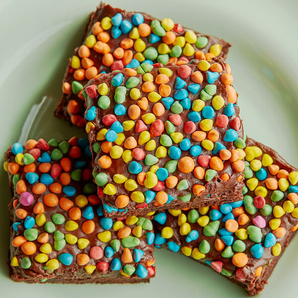 A group of brownies with colorful candies on top.