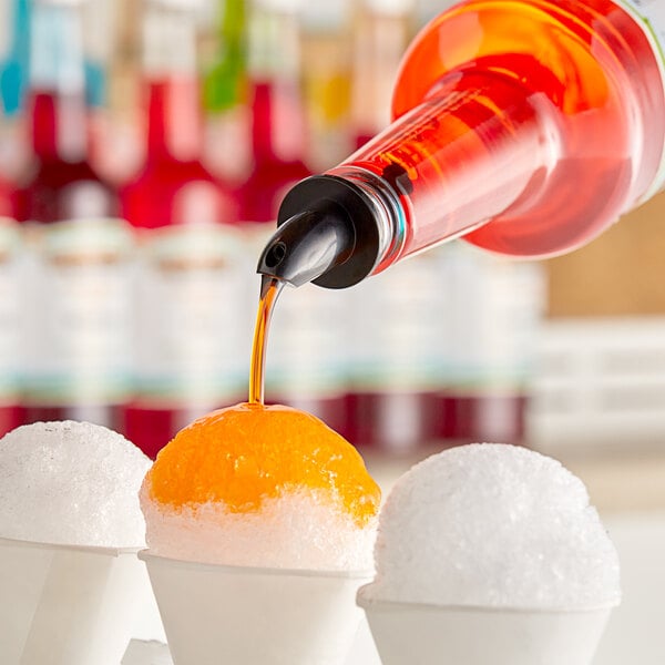 A person pouring Hawaiian Shaved Ice Dreamsycle syrup over a bowl of ice.