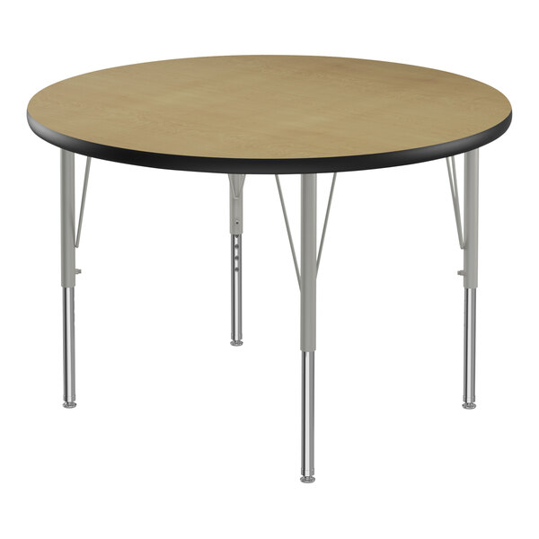 A close-up of a Correll round activity table with metal legs and a black top.