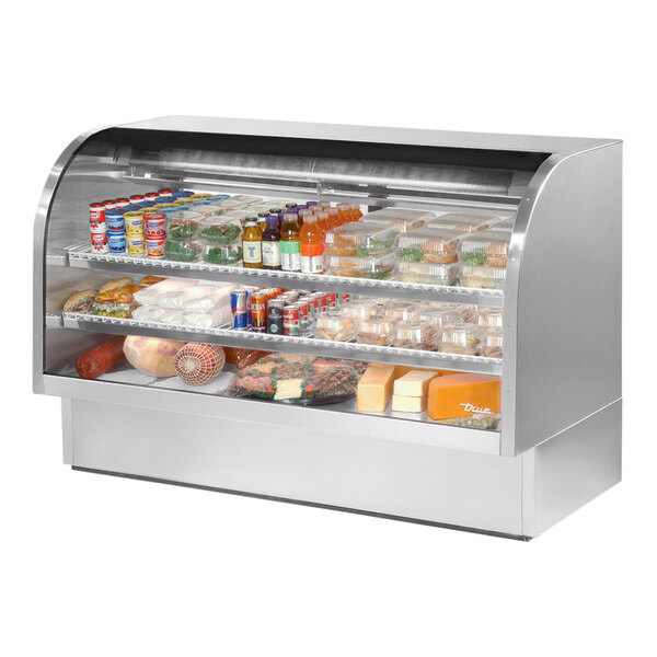 A True stainless steel curved glass deli case filled with food.