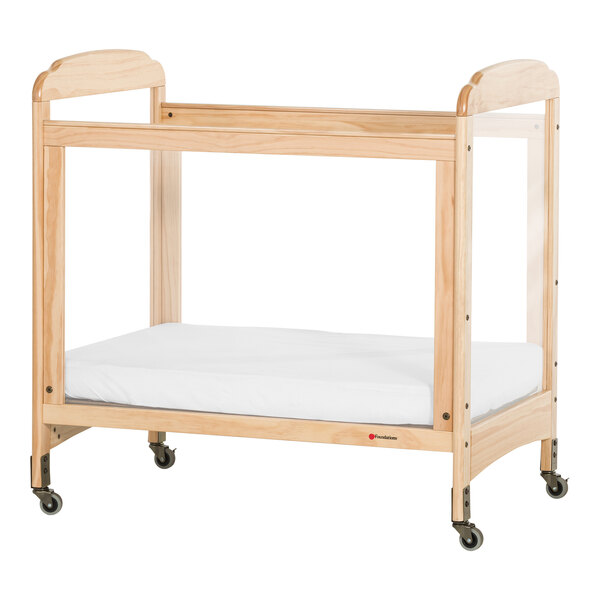 Foundations Next Gen Serenity 24" x 38" Natural Compact Fixed-Side Wood Crib with SafeSupport Frame, 4 ClearView Panels, and 3" InfaPure Mattress